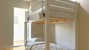 A bunk bed with a ladder, a wooden floor, and a door leading to a bright room. - Gray Corner Place | Walk Score 90 | Sleeps 9 (Washington)