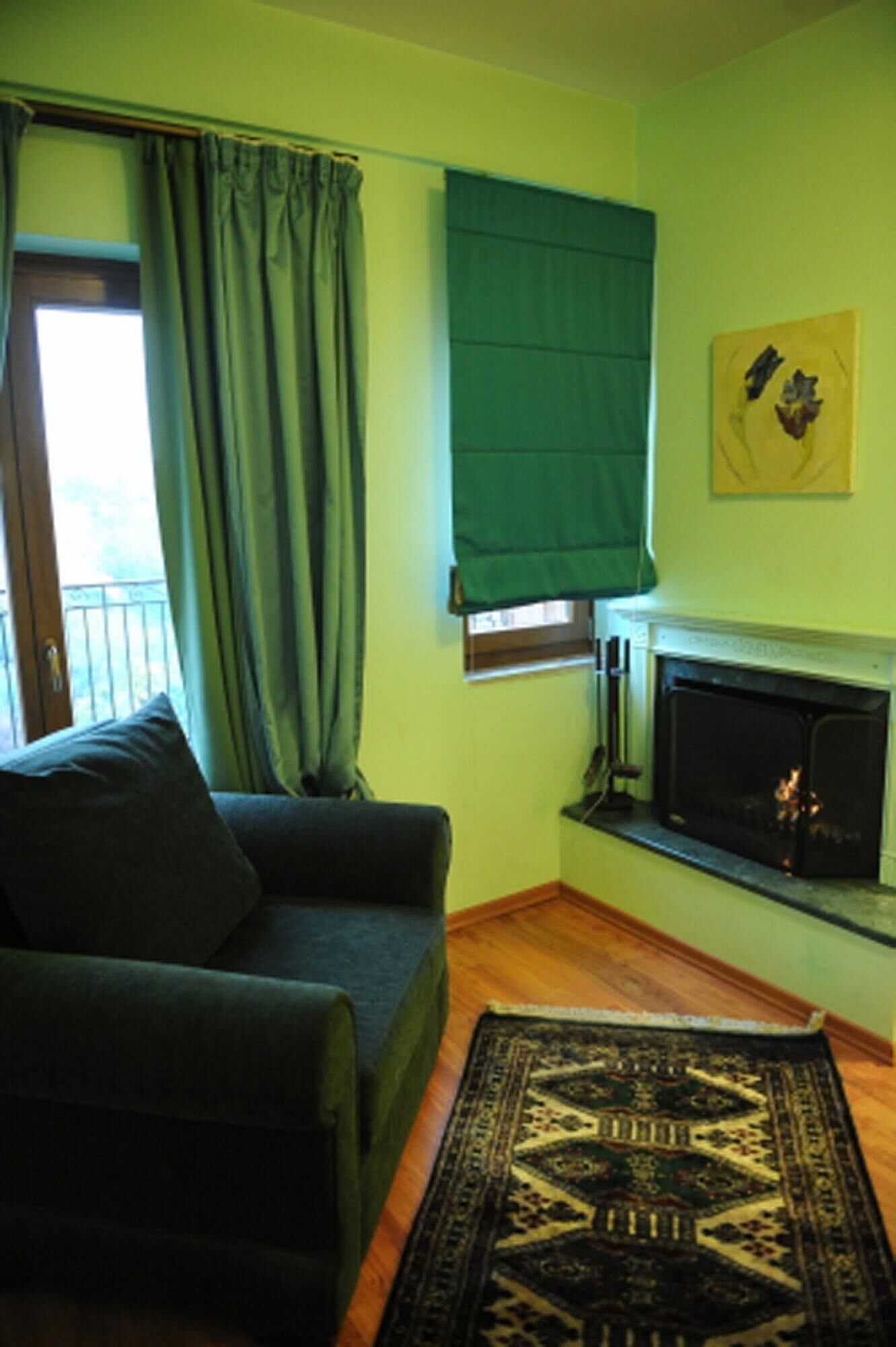 A living room with a sofa, a fireplace, a window with curtains, and a rug.