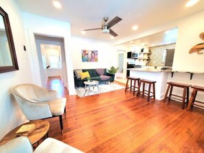 Relax in this open-plan living and dining area with a sofa, coffee table, and kitchen bar.