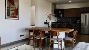 Een moderne keuken met donkere houten kastjes, roestvrijstalen apparatuur en een groot eiland met stoelen.
