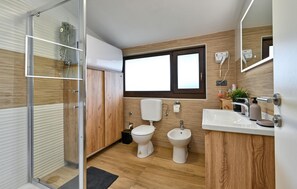 A modern bathroom with a glass shower enclosure, a toilet, a bidet, and a sink with a mirror. - Cozy home in Legrad with sauna (Legrad)
