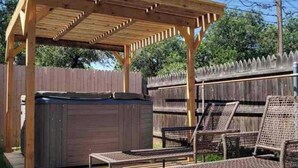 A wooden deck with a pergola, a hot tub, and outdoor seating. - Take me to Italy! an oasis of luxury in central Lubbock (Lubbock)