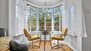 A sunroom with a glass ceiling, two yellow chairs, a round table, and a chandelier. - Take me to Italy! an oasis of luxury in central Lubbock (Lubbock)