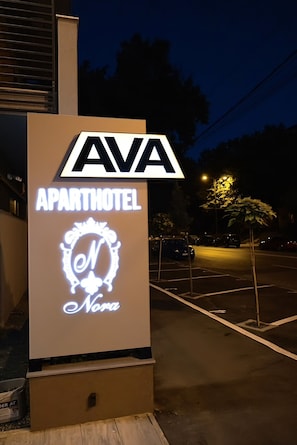 Une enseigne pour l’hôtel Ava Aparthotel, avec un logo et le nom de l’établissement.