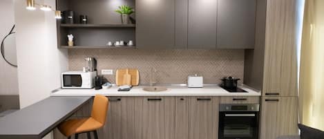 A modern kitchen with a bar area, built-in appliances, and a minimalist design.