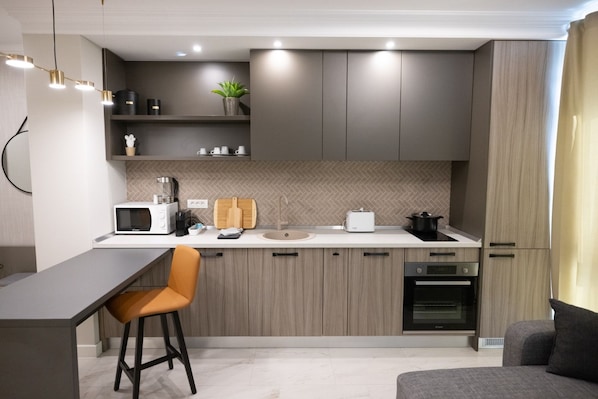A modern kitchen with a bar area, built-in appliances, and a minimalist design. - Ava Apart By Nora (Timisoara)