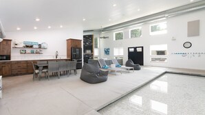 Una cucina moderna con zona pranzo, piscina e area relax con posti a sedere.