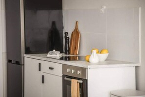 A kitchen with a built-in oven, a microwave, and a sink. - Spacious & Bright 3BR Apartment (Tel Aviv-Jaffa)
