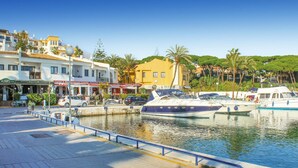 A marina with boats docked, a waterfront promenade, and buildings with restaurant signs. - Beautiful home in Marbella (Marbella)