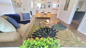 Un salon avec un canapé beige, une table basse et une grande plante verte.