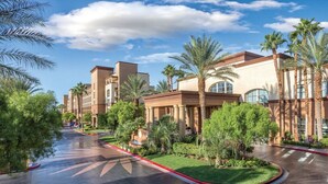 A hotel with a curved driveway, palm trees, and a clear sky. - 1BD Las Vegas Boulevard w/Lazy river, Shuttle and near the Strip! (Las Vegas)