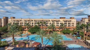 A hotel with multiple balconies, a central swimming pool, and palm trees. - 1BD Las Vegas Boulevard w/Lazy river, Shuttle and near the Strip! (Las Vegas)