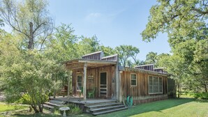 Un rustico chalet in legno con veranda, immerso nel verde.