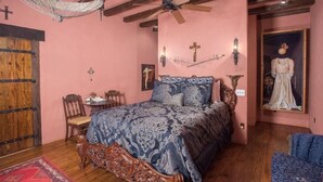 Ein Schlafzimmer mit einem großen Bett, einem Holzschrank, einem Schreibtisch und einem Stuhl.