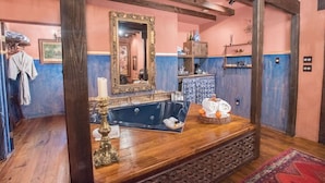 Ein Badezimmer mit Badewanne, Spiegel und Holzbalken.
