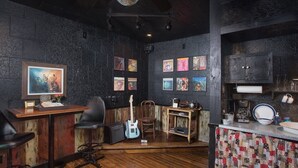Een gezellige kamer met een houten bar, een gitaar en een vintage radio.