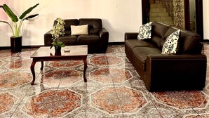 Ein Wohnzimmer mit zwei Sofas, einem Couchtisch, einer Topfpflanze und einer Chandelier.