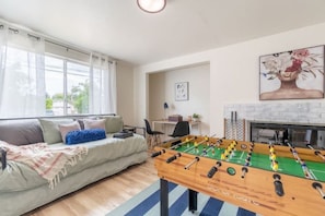 A cozy living room with a foosball table, a sofa, and a fireplace. - Modern Charm/Large families and friend groups (Concord)