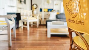 Una sala de estar moderna con una silla de madera que dice "Cafés Auténticos" y un sofá.
