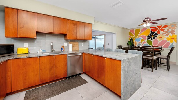 Una cocina moderna con armarios de madera, lavavajillas integrado y una isla grande.