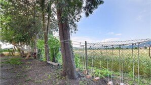 A fenced outdoor area with a rope bridge and swings, surrounded by trees and a field. - Stunning apartment in Monselice (Monselice)