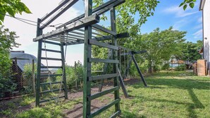 A wooden structure with a ladder and a swing set in a grassy area with trees. - Stunning apartment in Monselice (Monselice)