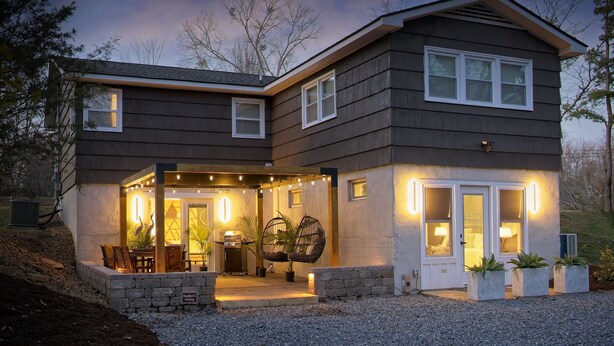 A two-story house with a covered patio area, outdoor seating, and a stone retaining wall. - Ultimate Space for Your Family! ~ TIEC ~ Fire Pit+ (Landrum)