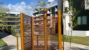 Una entrada protegida con valla de madera y un sendero empedrado que conduce a un edificio de diseño moderno.