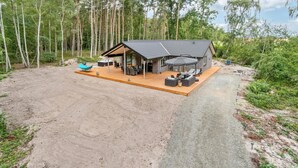 Une cabane dotée d’un patio, d’un espace salon extérieur et d’une cuisine extérieure couverte.