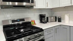 A kitchen with a stove, microwave, toaster, and coffee maker.