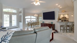 A spacious living room with a large sectional sofa, a dining area with a wooden table and chairs, and a kitchen area with modern appliances. - Pool, Grill & Golf Course Views: Spring Hill Stay! (Spring Hill)