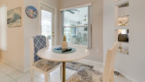 A dining area with a round table, chairs, and a decorative pineapple centerpiece. - Pool, Grill & Golf Course Views: Spring Hill Stay! (Spring Hill)