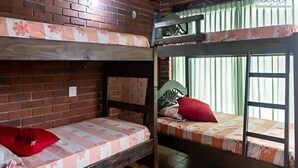 A dormitory room with two bunk beds, a brick wall, and a window with vertical blinds. - Villa Lago Calima, a 5 min del Pueblo y Lago (Valle del Cauca)