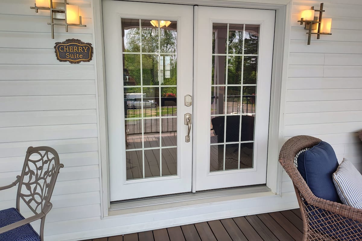 A white door with glass panels, a 'Cherry Suite' sign, and two wall-mounted lights.