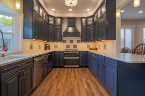 Una cocina moderna con armarios oscuros, una isla central y un horno empotrado.