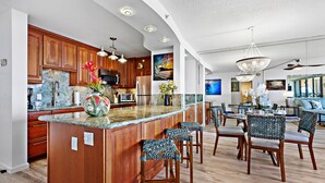 Une cuisine moderne avec des meubles en bois, un grand îlot central et des tabourets de bar.