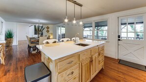 A spacious kitchen with a large island, wooden cabinets, and pendant lighting. - Bryson City Mtn Retreat w/ Hot Tub (Bryson City)