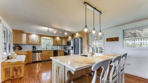 A spacious kitchen with wooden cabinets, a central island, and pendant lighting. - Bryson City Mtn Retreat w/ Hot Tub (Bryson City)