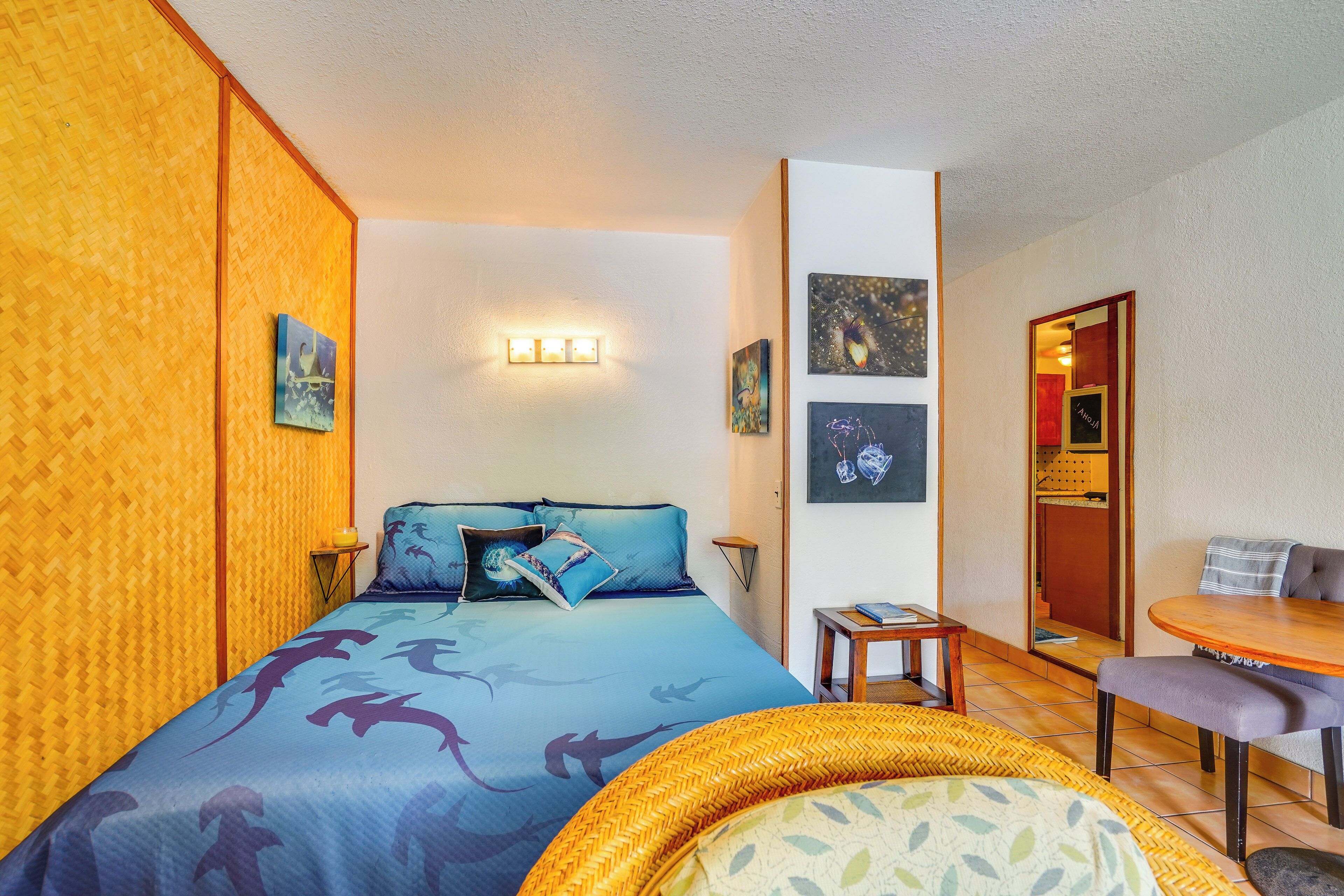 A hotel room with a bed, a small table, a chair, and a sofa.