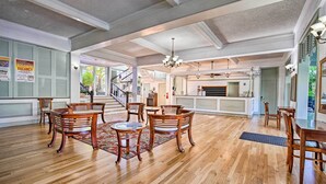 A spacious dining area with wooden furniture and a central chandelier.