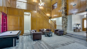 A spacious living area with a pool table, leather sofas, and a stone pillar. - Outdoor Pool & Lake: Massive Texas Ranch Villa! (Commerce)