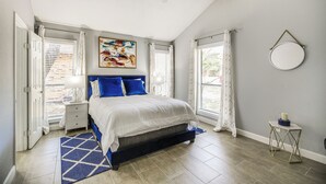A bedroom with a bed, a ceiling fan, a window with curtains, a bedside table, and a wall-mounted mirror. - Serene San Antonio Vacation Home w/ Smart TVs (San Antonio)