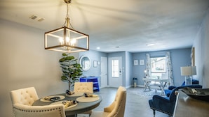 A dining area with a round table, four chairs, and a hanging light fixture. - Serene San Antonio Vacation Home w/ Smart TVs (San Antonio)