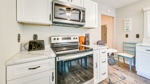 A kitchen with white cabinets, a microwave, an oven, and a ceiling fan. - 3 Mi to Burnside Marina: Lake Cumberland Getaway (Somerset)