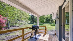 A covered deck with a grill, wooden railing, and a view of a landscaped garden. - 3 Mi to Burnside Marina: Lake Cumberland Getaway (Somerset)