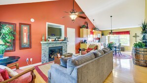 Un salon avec une cheminée, un canapé et un coin repas comprenant une table et des chaises.