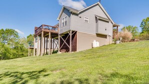 Une maison à deux étages avec une terrasse en bois et un grand garage.