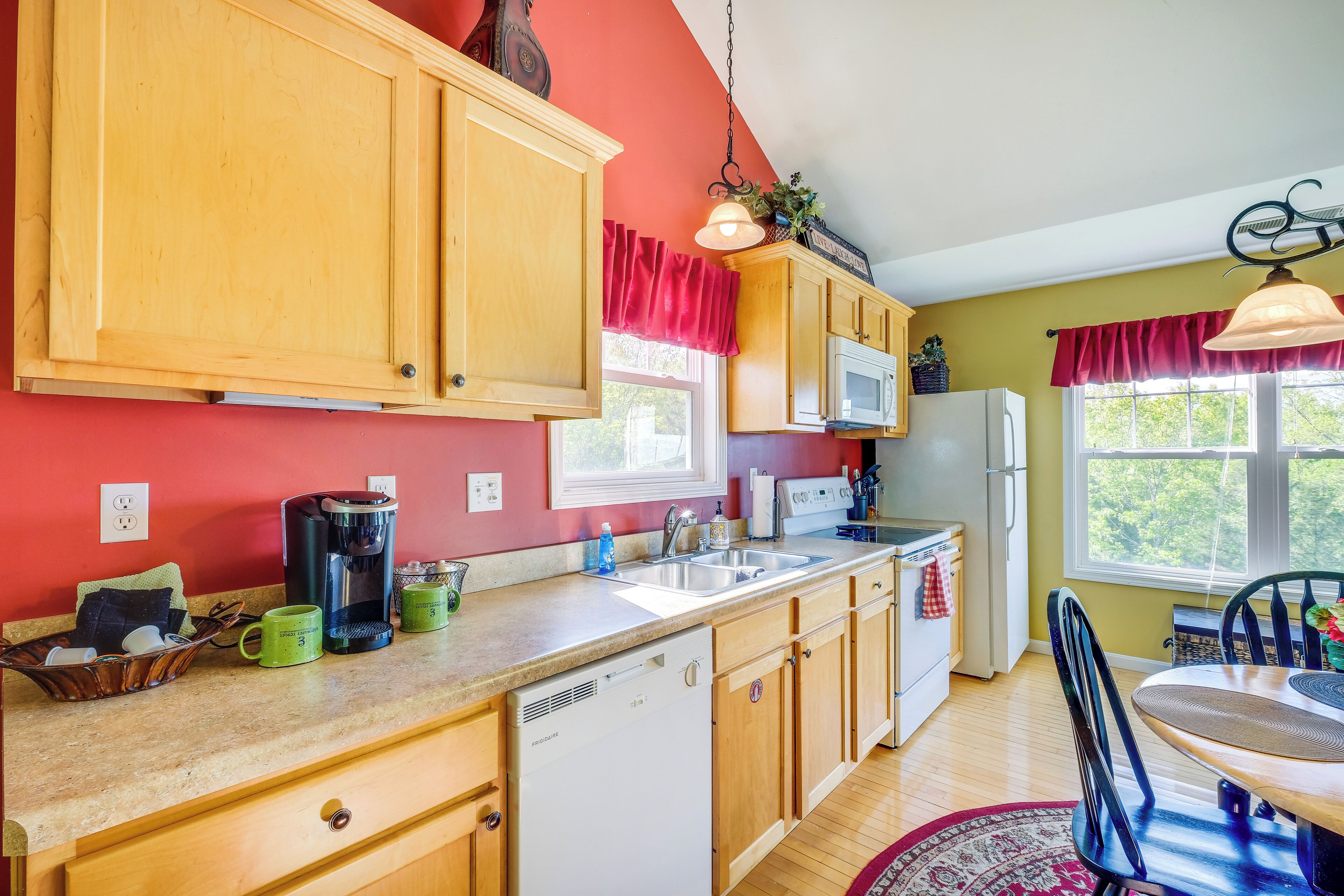 A kitchen with wooden cabinets, a microwave, a coffee maker, and a sink.