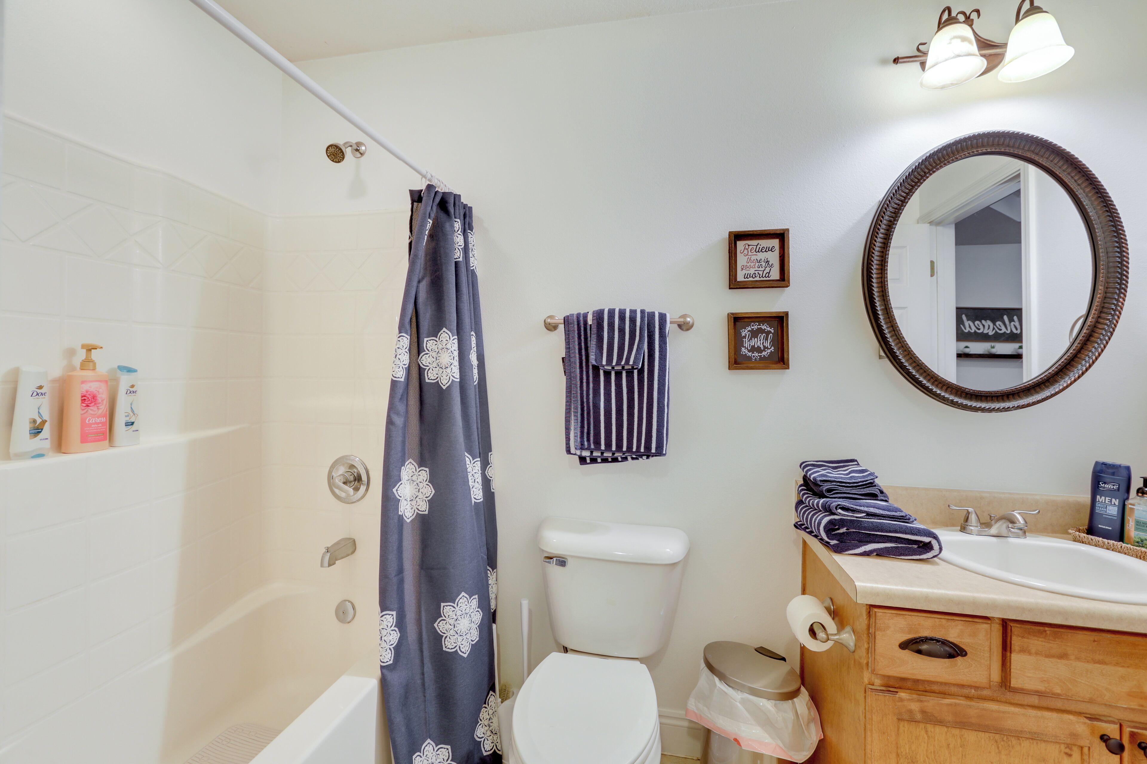 A bathroom with a shower, toilet, sink, and vanity.