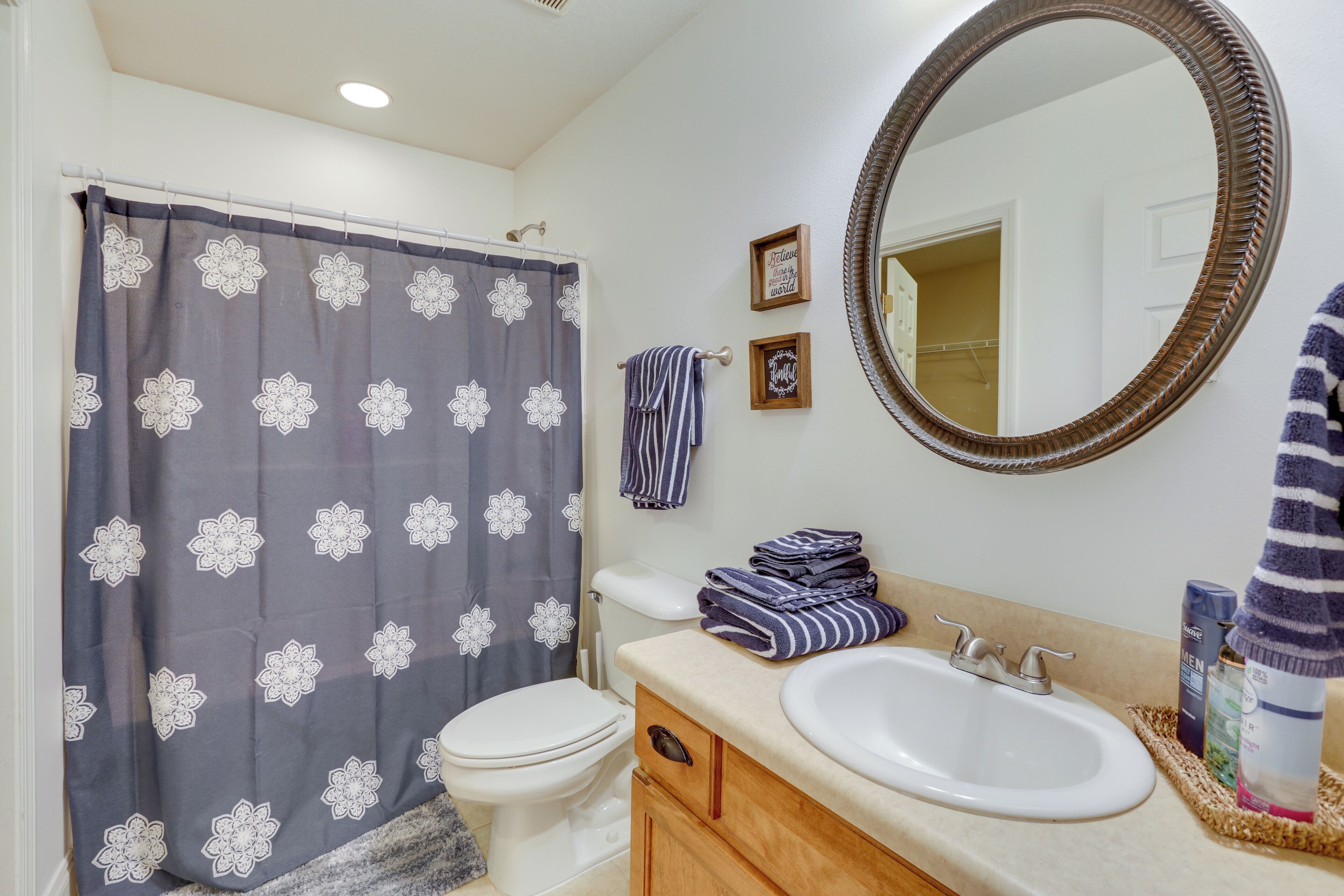 A bathroom with a toilet, sink, and shower curtain.